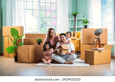 House move concept. Happy Indian young family sitting on the floor in new home - Powered by Shutterstock