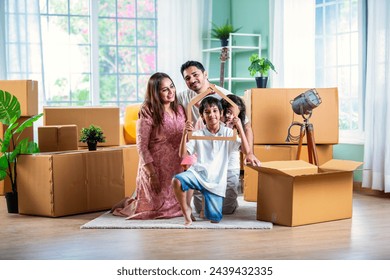 House move concept. Happy Indian young family sitting on the floor in new home - Powered by Shutterstock