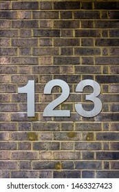 House Number 123 On A Brick Wall