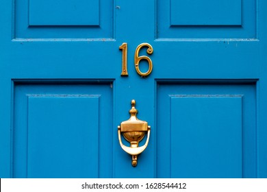 House Number 16 On A Blue Wooden Front Door With Door Knocker