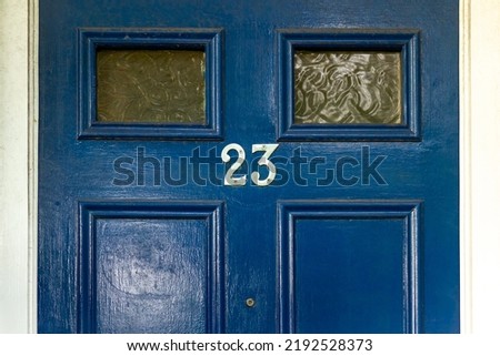 House number 23 on a blue wooden front door