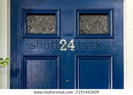 House number 24 on a blue wooden front door