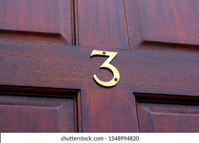 House Number 3 On A Diagonally Slanted Wooden Front Door