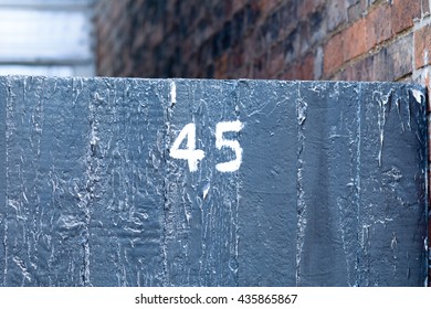 House Number 45 Sign Painted On Gate