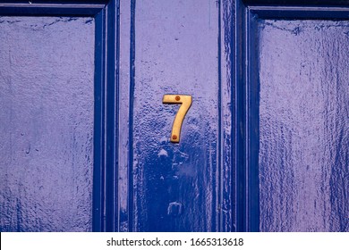 House Number 7 On A Blue Wooden Front Door Gleaming In The Sunlight