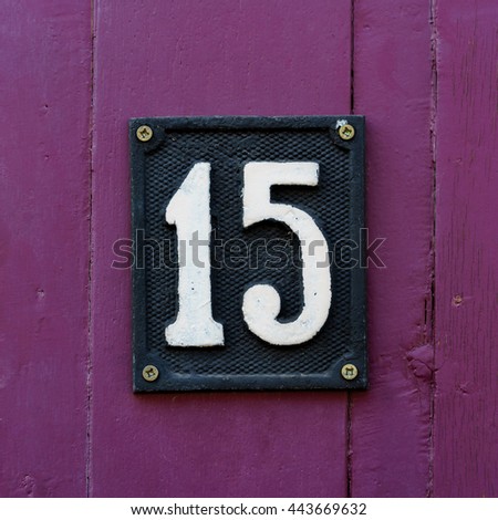 House number fifteen made out of cast metal.