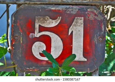 A house number plaque, showing the number fifty one (51)
