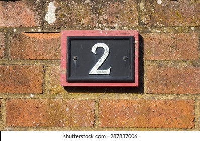 House number two sign on a red brick wall - Powered by Shutterstock