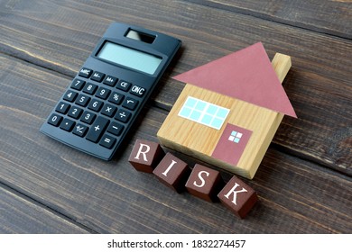 House object and calculator with wooden blocks with risk word - Shutterstock ID 1832274457