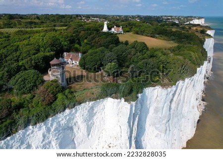 House and old lighhouse close to edge of white cliffs of Dover Kent UK drone aerial view 