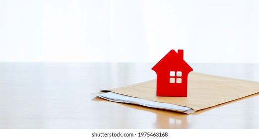House on document envelope. complete the insurance policy, rental documents and loan document. concept guy buying new house