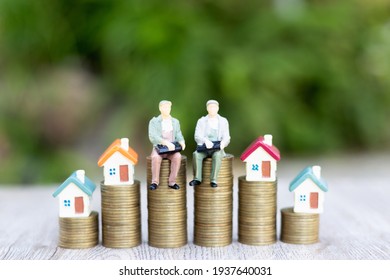 The house on the ladder A model businessman on a pile of coins Business Startup Ideas Mortgage and Real Estate Investing Money Savings Investing Risks. - Powered by Shutterstock