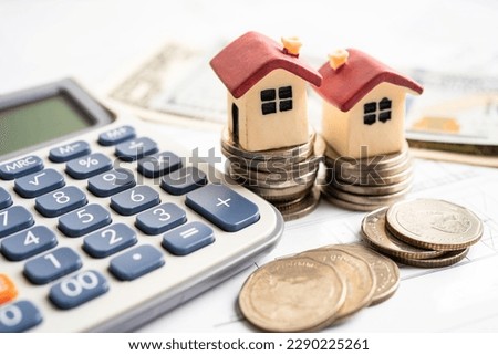 House on stack coins with calculator, mortgage home loan finance concept.