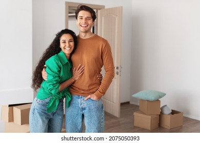 House Ownership. Happy Young Couple Standing In New Flat With Cardboard Boxes On Floor, Cheerful Guy And Lady Posing Hugging After Moving In Own Apartment. Insurance, Real Estate, Mortgage Concept - Shutterstock ID 2075050393