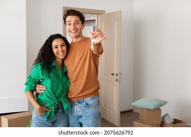 House Ownership. Portrait Of Happy Young Couple Holding Showing Key Standing In New Flat, Cheerful Guy Embracing Lady Posing After Moving In Own Apartment. Insurance, Real Estate, Mortgage Concept - Shutterstock ID 2075626792