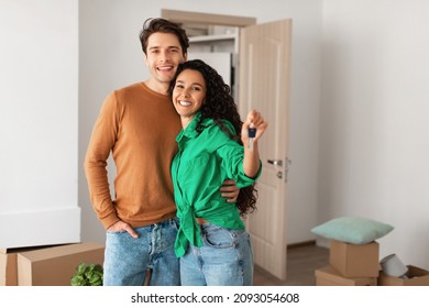 House Ownership. Portrait Of Happy Young Couple Holding Showing Key Standing In New Flat, Cheerful Guy Embracing Lady Posing After Moving In Own Apartment. Insurance, Real Estate, Mortgage Concept - Shutterstock ID 2093054608
