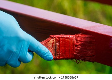House painter paints metal structures. Protective coating of steel closed profiles with primer iron oxide red. - Shutterstock ID 1738388639