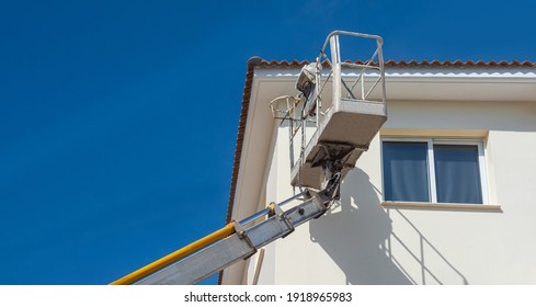 House Painting. Painting The Building. The Painter Works At Height. Exterior Decoration Of The House. Painting The Walls Of The Building. Special Cradle For High-rise Works.