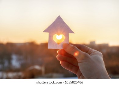 House Of Paper With A Heart In The Hand On The Rising Sun Background.