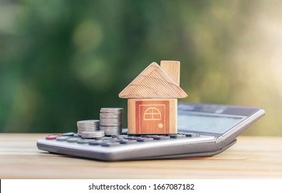 House is placed on the calculator and coin is on the calculator. planning savings money of coins to buy a home concept for property ladder, mortgage and real estate investment saving for a buy house.
