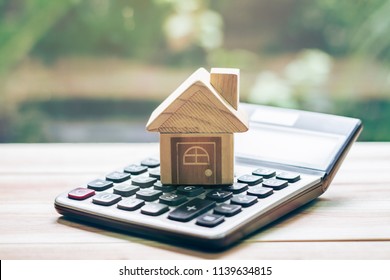 House is placed on the calculator. Imagine calculating to buy a home. planning savings money of coins to buy a home concept for property, mortgage and real estate investment.to buy a house. - Shutterstock ID 1139634815