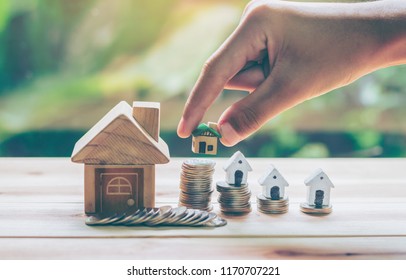 House placed on coins Men's hand is planning savings money of coins to buy a home concept concept for property ladder, mortgage and real estate investment. for saving or investment for a house, - Shutterstock ID 1170707221