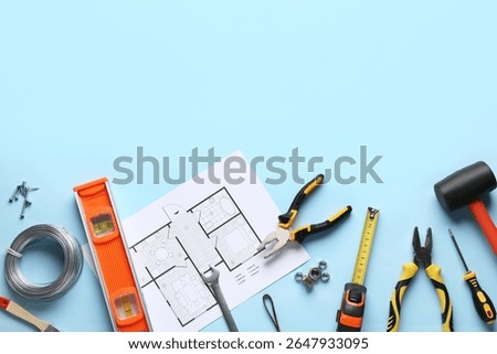 House plan and construction tools on blue background