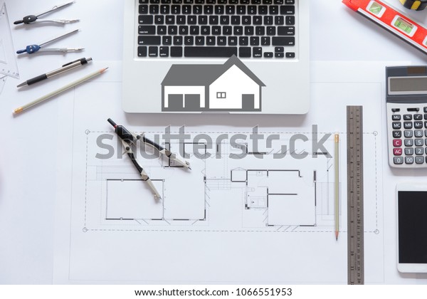 House plan with roll blueprints,\
ruler, dividers, pencil, security helmet and architect\
equipment