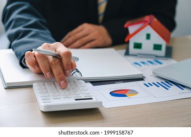 House plans with real estate agents and clients calculating the first lump sum for a home purchase contract, insurance or real estate loan