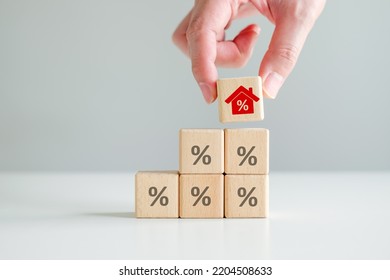 House And Property Investment And Asset Management Concept. Interest Rates, Loan Mortgage, House Tax. Hand Holding House Icon With Percent Sign From Stack Of Blocks With Percentage Icon