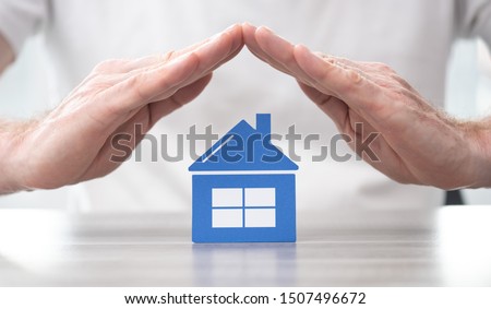 House protected by hands - Concept of home insurance