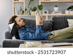 House, relax and man on sofa, smartphone and typing with break, connection and social media. Apartment, person and guy on couch, mobile user and cellphone with internet, comfortable and communication