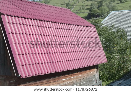 House with a roof made of solid metal sheets, shaped like an old tile