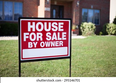 House For Sale By Owner Sign In A Front Yard Of A House