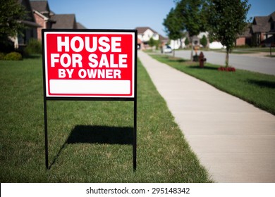 House For Sale By Owner Sign In A Front Yard Of A Home