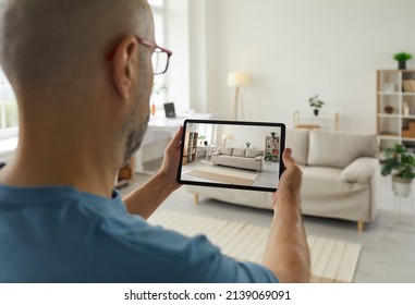 House seller giving a virtual video tour around his recently renovated home. Adult man who plans on selling his sofa or his whole studio apartment takes a photo of the stylish interior on a tablet