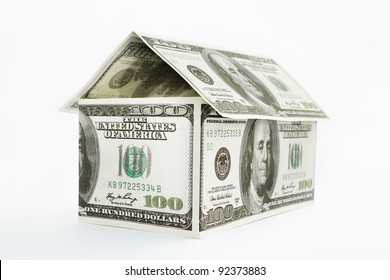 House shape made from 100 dollar bills over white background