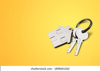 House Shaped Keychain And Keys On Desk