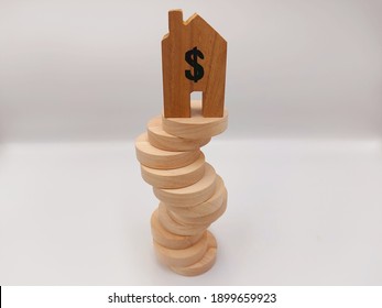 House Shaped Wooden Block At The Top Of A Winding Disc Stack, To Represent The Uncertainty Within The Housing Market Or An Unstable Foundation