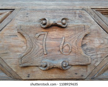 House Sign Number 76: Wooden Digits Carved On An Old Door