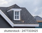A house with a slanted roof and a window on the top. garret house with roof shingle.