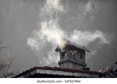 House With A Smoking Chimney In A Cold Winter Day