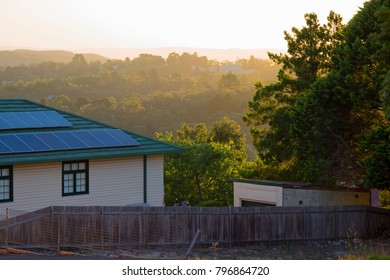 House With Solar Panels On Roof In A Mountain Landscape At Sunset. Wooden Building With A Background Of Mountainous Forest At Dusk. Heritage Architecture And Modern Technology In Australia.