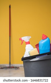 House Spring Cleaning Items Or Supplies In A Bucket On A Tile Floor. Mop In A Background. Vertical Orientation.