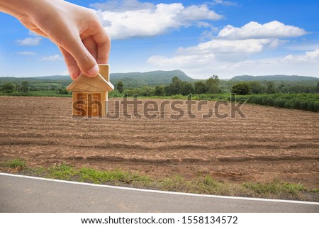 House symbol with location pin and Empty dry cracked swamp reclamation soil, land plot for housing construction project with and beautiful blue sky with fresh air Land for sales landscape concept