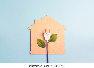 House Symbol With Plug Like A Plant On A Blue  Background. Save Energy Concept. Flat Lay, Top View.