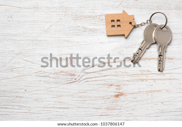 House symbol with silver keys on wood. Real\
estate concept