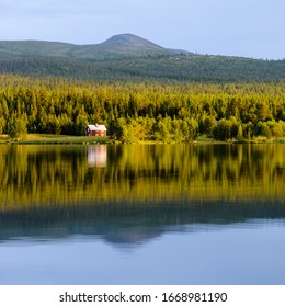 House and trees reflected on still lake, Sweden - Powered by Shutterstock