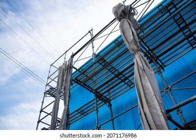 House Under Construction Covered With Blue Tarp.