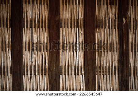 House wall made of bamboo sticks  alternate with square wood poles.